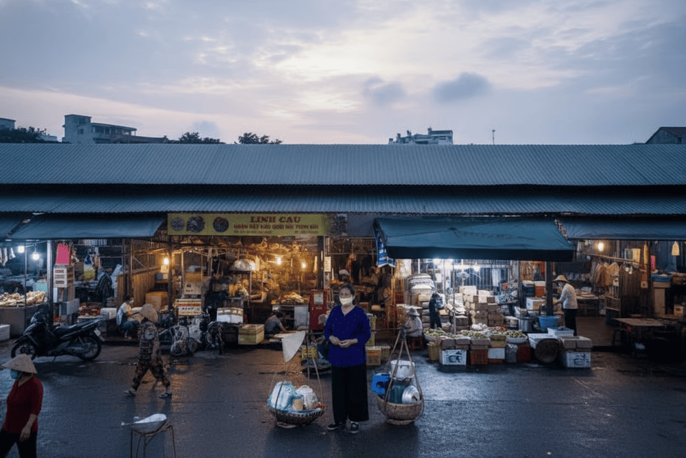 Một g&aacute;nh h&agrave;ng b&aacute;n đồ ăn nhỏ nằm ngay b&ecirc;n cạnh sạp b&aacute;n hoa v&agrave; đồ kh&ocirc; tại chợ Long Bi&ecirc;n (Nguồn: Internet)